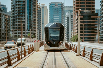 A tram in the middle of the road near buildings