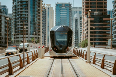 A tram in the middle of the road near buildings