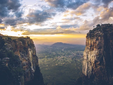 Scenic mountain cliffs with a dramatic sunset and valley view