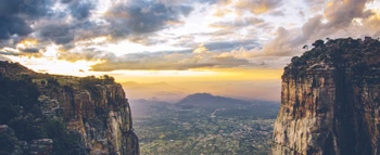 Scenic mountain cliffs with a dramatic sunset and valley view
